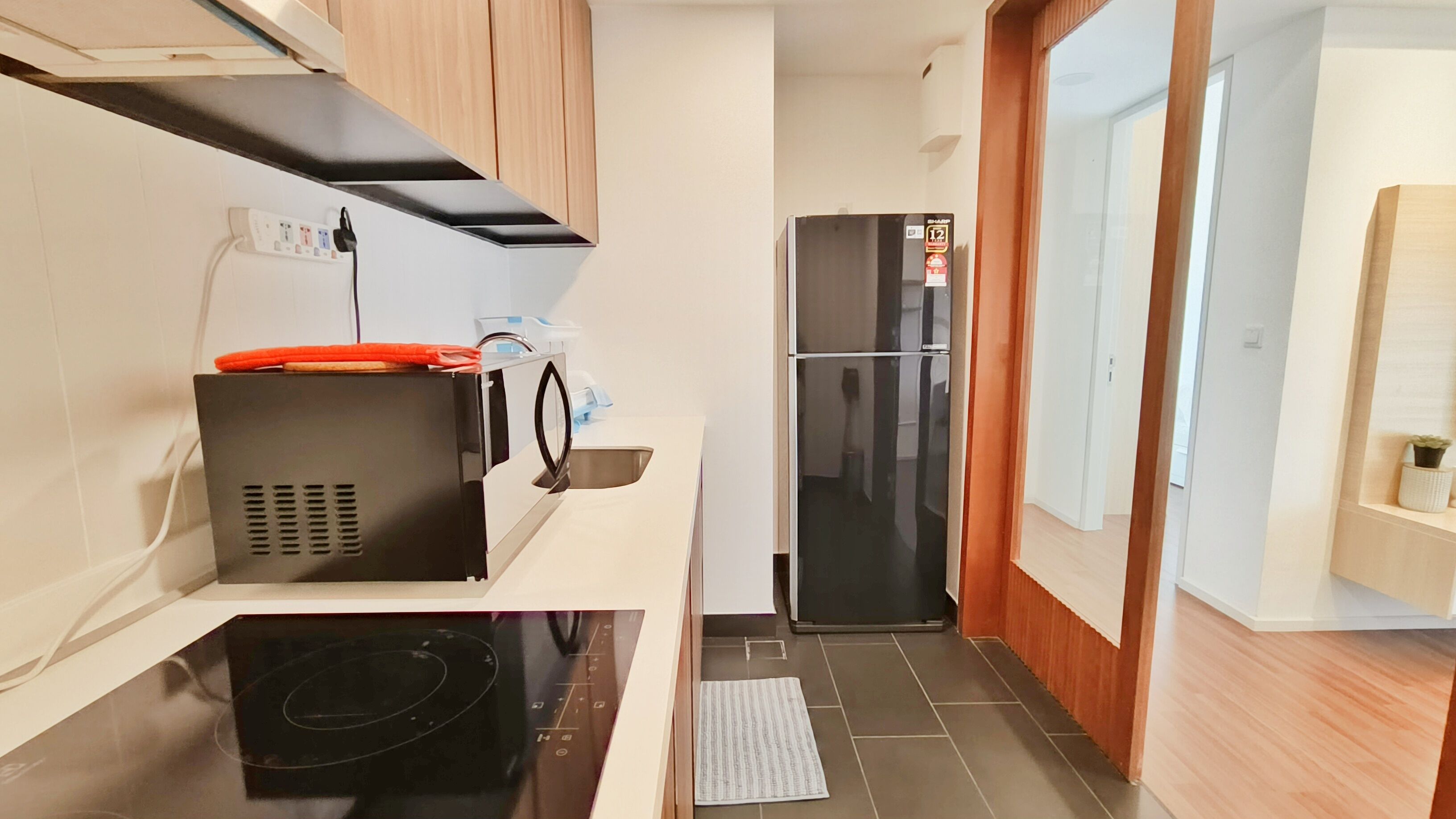A compact kitchen with a microwave, stove, and refrigerator.