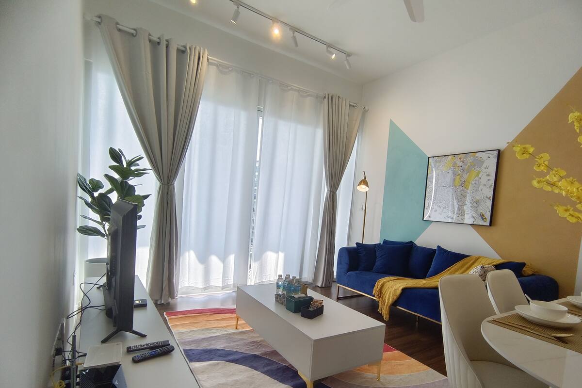 A modern living room with a sofa, coffee table, and a dining area with chairs and a table.