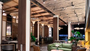 A spacious lobby with a bar area, seating arrangements, and a modern ceiling design. - Luminor Hotel Legian Seminyak - Bali (Legian)