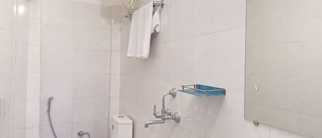 A modern bathroom with a toilet, bidet, sink, and a large mirror.