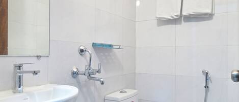 Un baño con lavamanos, inodoro y ducha.