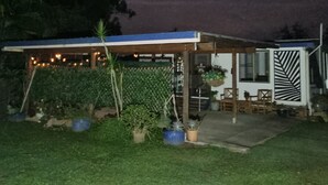 A house with a covered patio, potted plants, and a visible window.