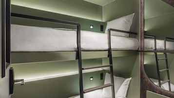 A bunk bed room with green walls and metal railings.