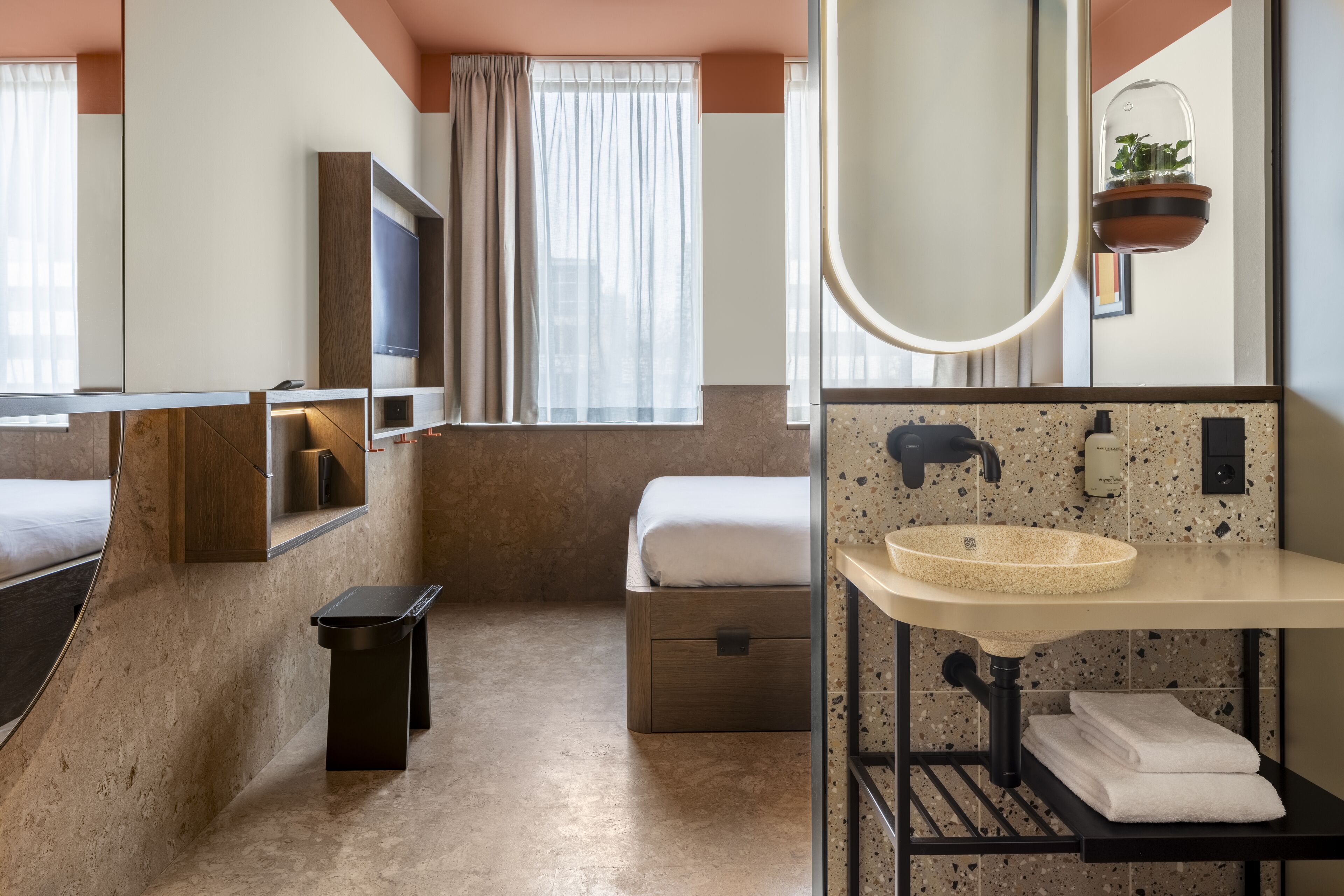 A modern bathroom with a large mirror, a sink, a toilet, and a shower area.