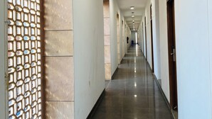 A long, narrow hallway with a patterned wall on one side and doors on the other.