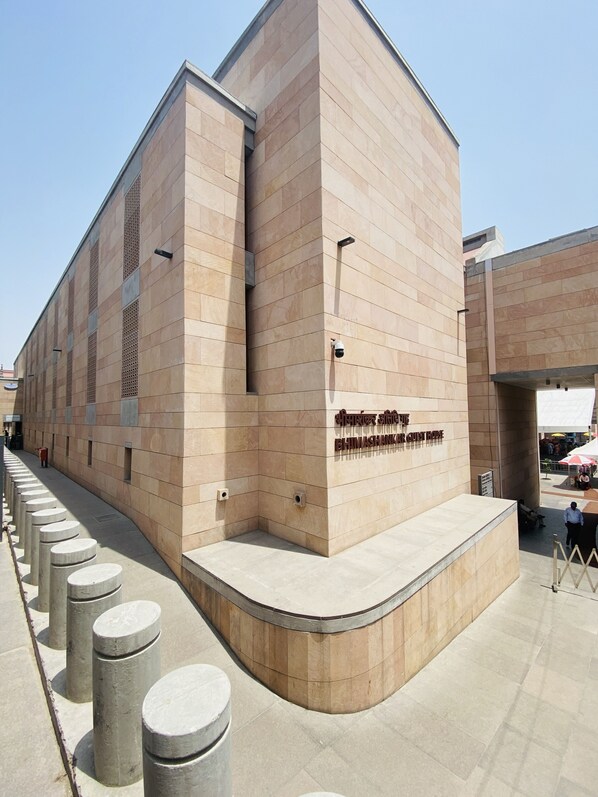 A modern building with a flat roof and a sign reading "BHIMASHANKAR GUEST HOUSE".