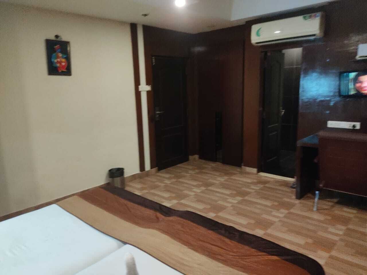 Een hotelkamer met een bed, bureau en televisie.