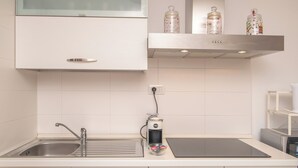 Una cuina moderna amb un vàter d'acer inoxidable, una cafetera i un forn de sobretaula.