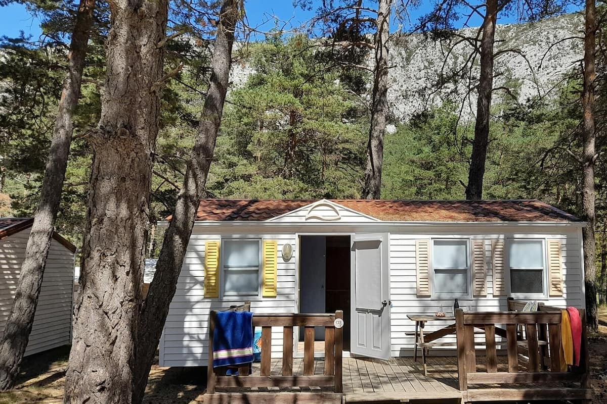 A small cabin with a front porch, a door, and a window.