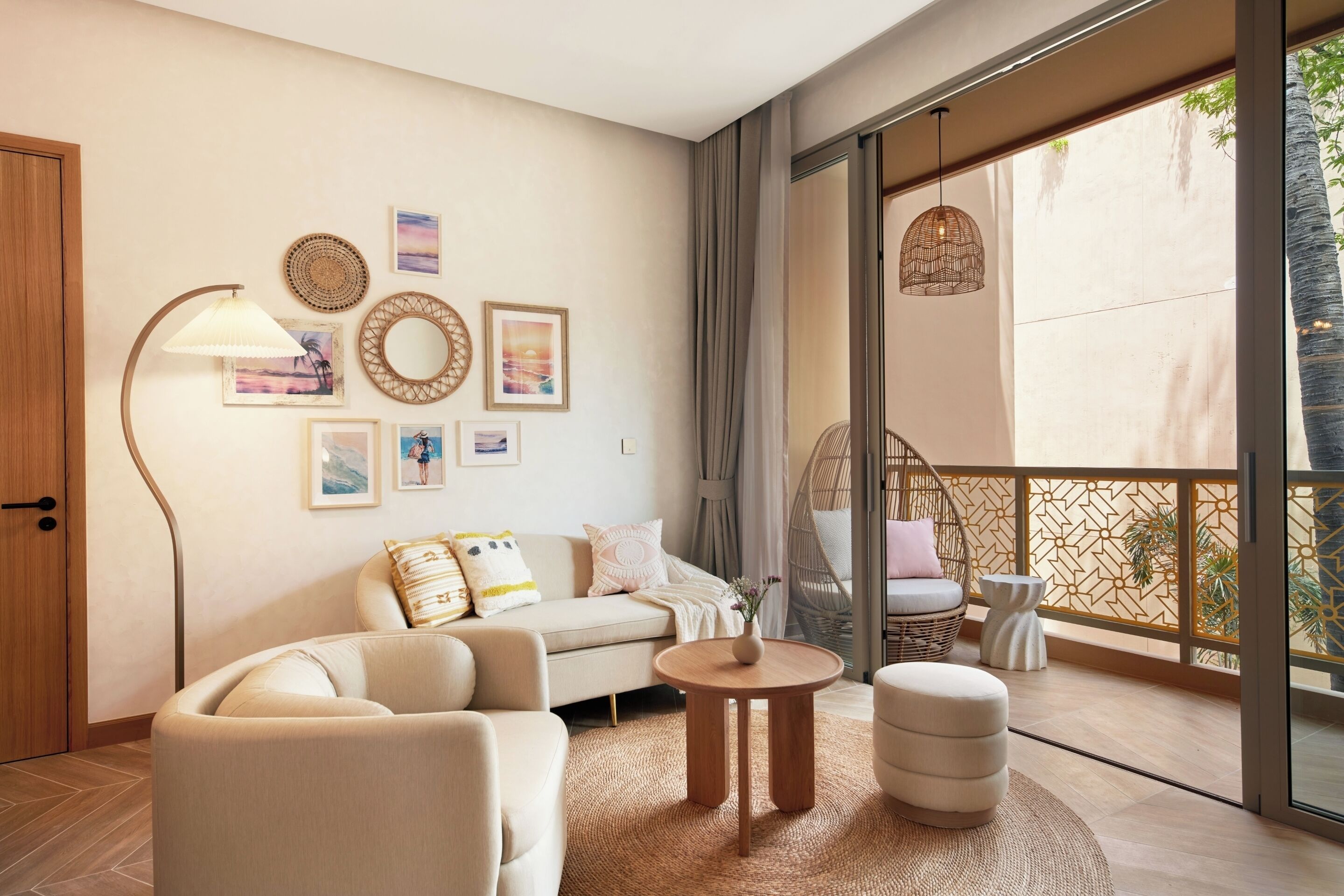 Un salon moderne avec un canapé, une table basse ronde en bois et un luminaire suspendu.