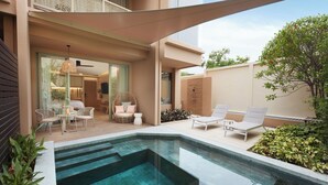 A modern outdoor pool area with lounge chairs, a dining set, and a glass-enclosed room.