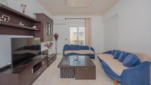 Un salon moderne avec un téléviseur à écran plat, un canapé, une table basse et un meuble pour téléviseur.