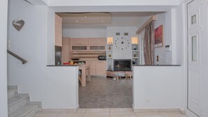 Une cuisine moderne avec des meubles en bois, un four encastré et un coin repas comprenant une table et des chaises.