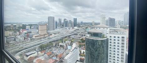 A cityscape with modern buildings, a prominent curved skyscraper, and a highway.