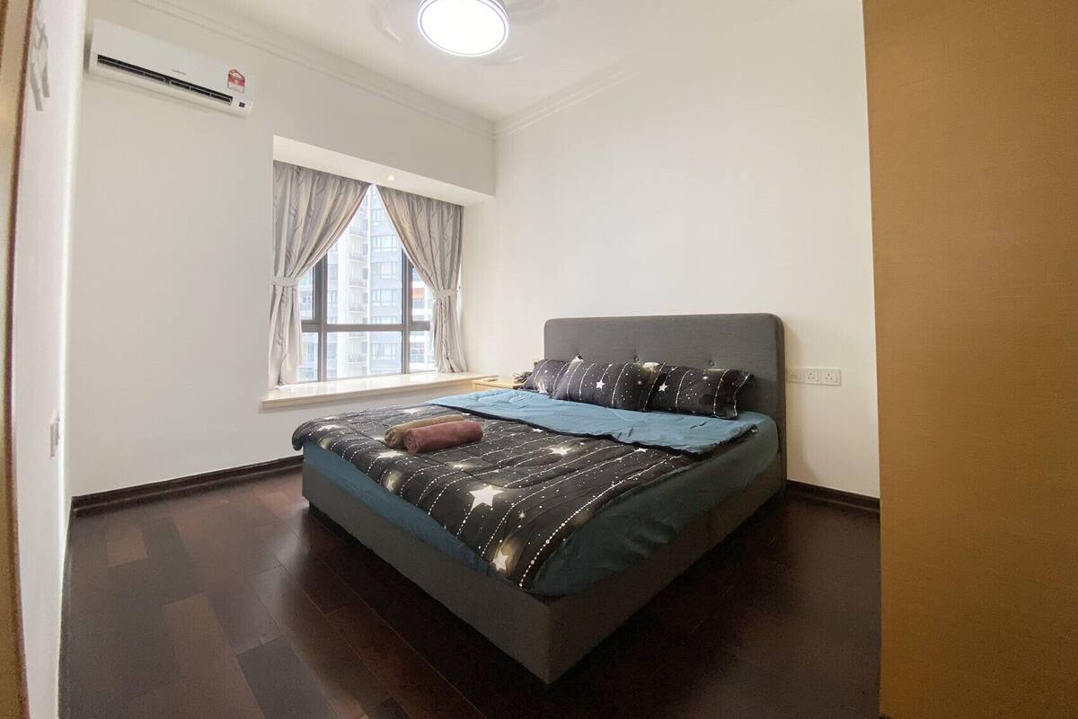 Une chambre à coucher avec un lit, une fenêtre avec des rideaux, un ventilateur de plafond et un appareil de climatisation.