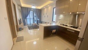A modern kitchen with a central island, stainless steel appliances, and a view to the outside. - R&F TrexHomestay (Johor Bahru)