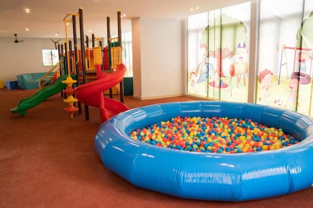 A children's play area with a slide, climbing structures, and a ball pit.