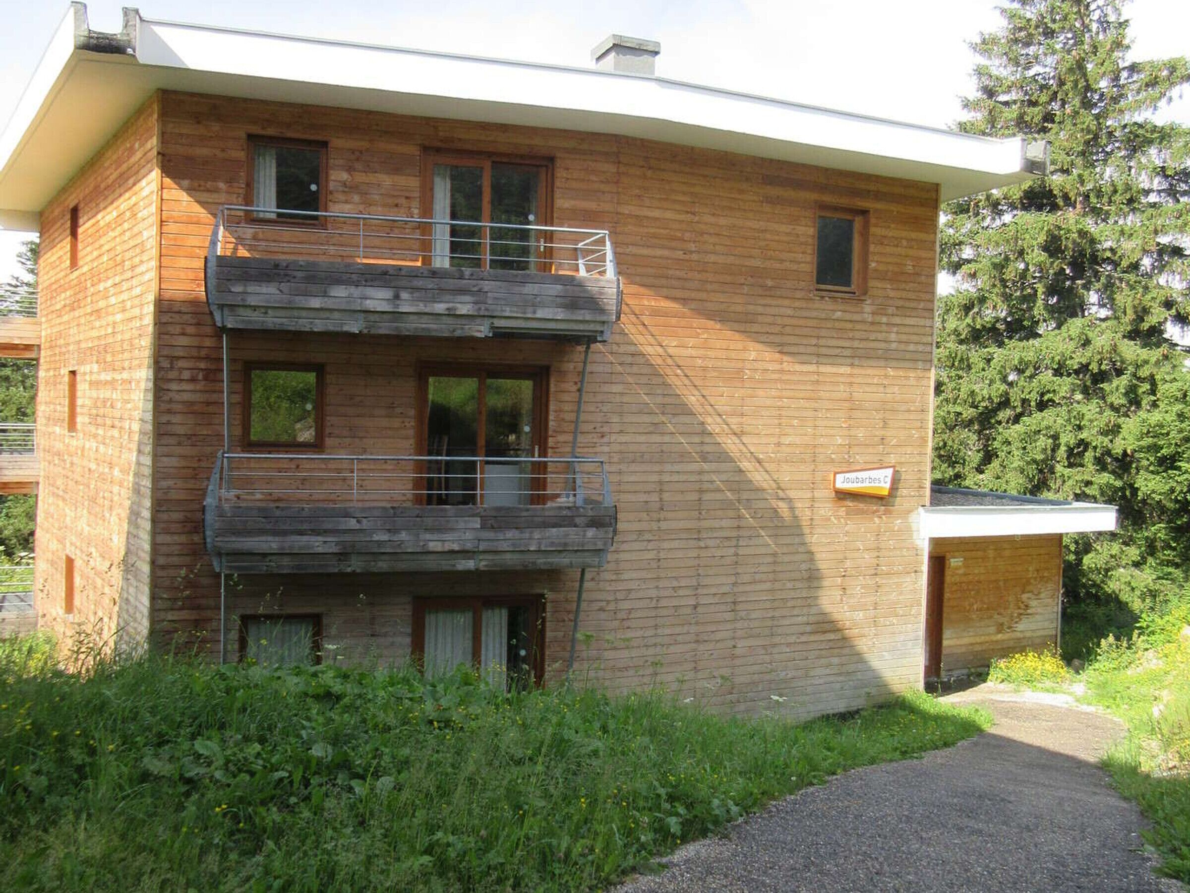 A two-story wooden building with a balcony on the upper floor.