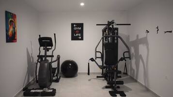 A gym with exercise equipment, a treadmill, and a stationary bike.