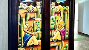 A stained glass window with a desert scene, including cacti and a figure reclining. - Hotel Villas Ponto Holbox (Isla Holbox)
