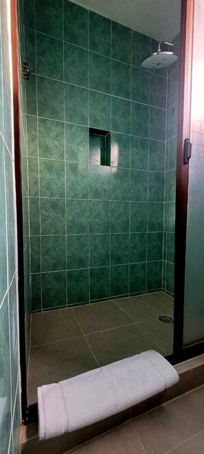 A shower area with green tiles and a white towel on the floor. - Hotel Villas Ponto Holbox (Isla Holbox)