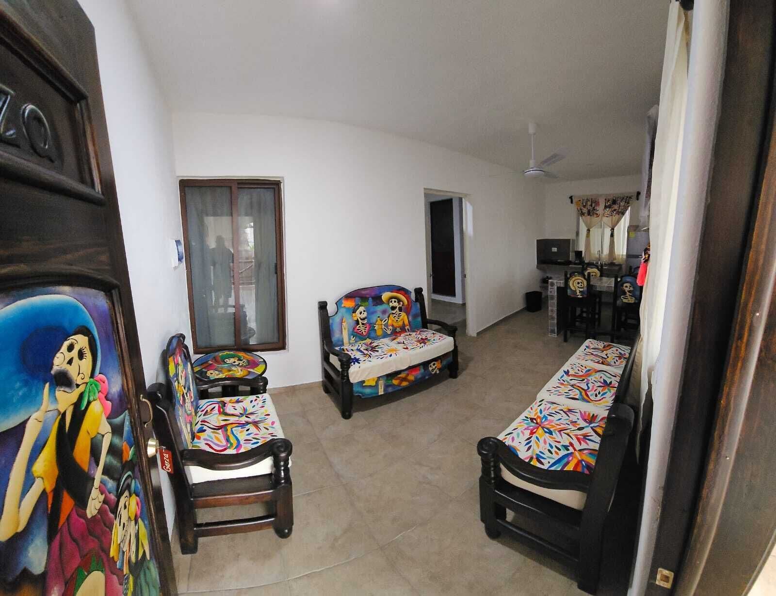 A room with two single beds, a chair, a television, and a door.