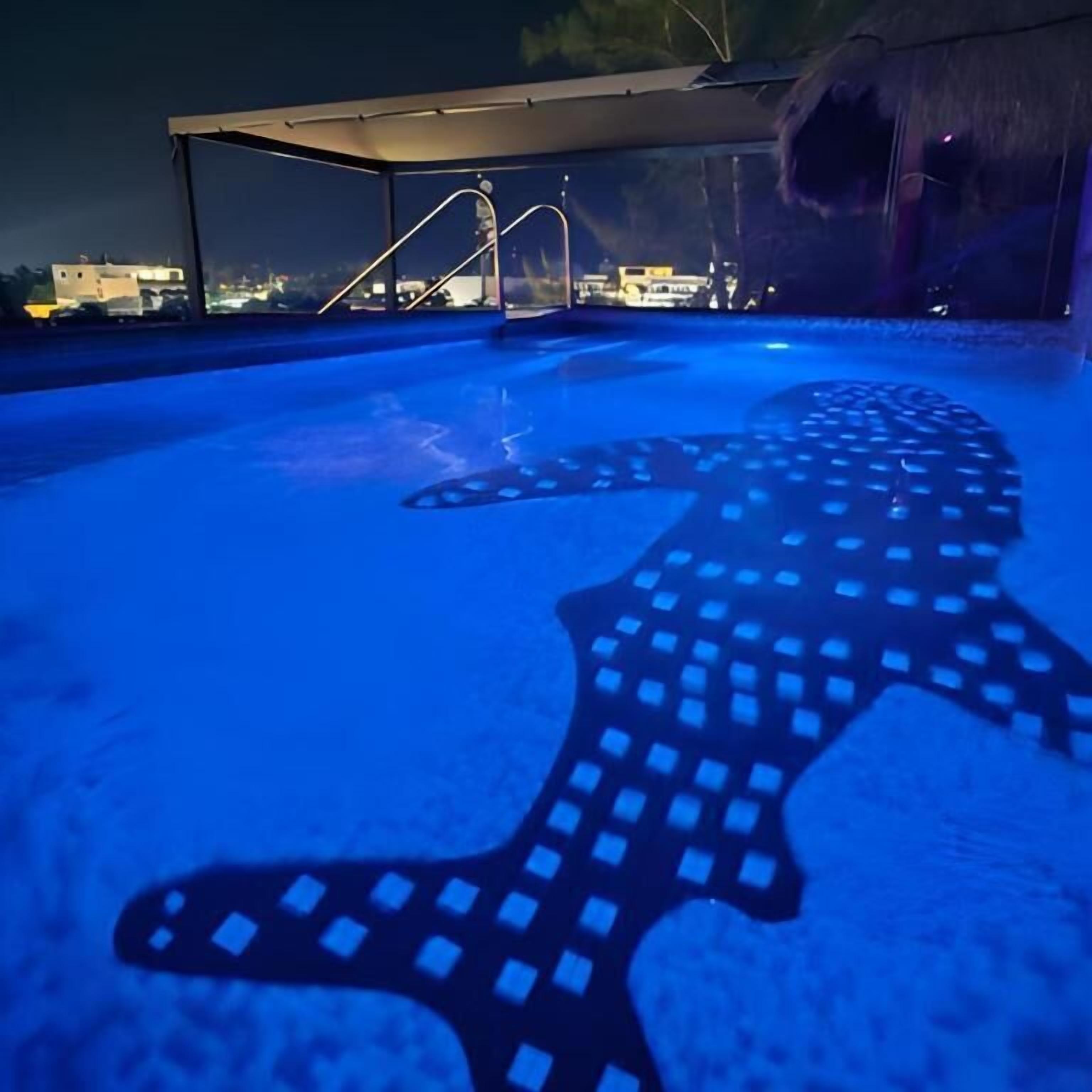 Una piscina con un diseño de luz en forma de tiburón en el suelo.