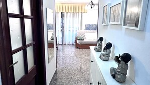 Habitación de hotel con cama, mesita de noche y cómoda. Hay tres objetos decorativos sobre la cómoda.