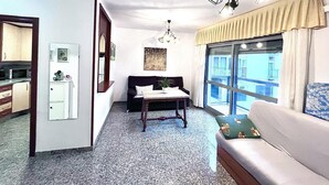 Un espacio habitable compacto con kitchenette, comedor y zona de estar con vistas.
