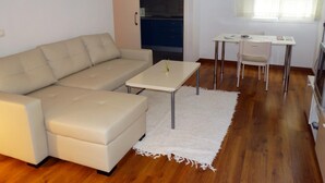 A modern living room with a beige sofa, a small white table, and a white rug. - Minimalist center loft (Córdoba)