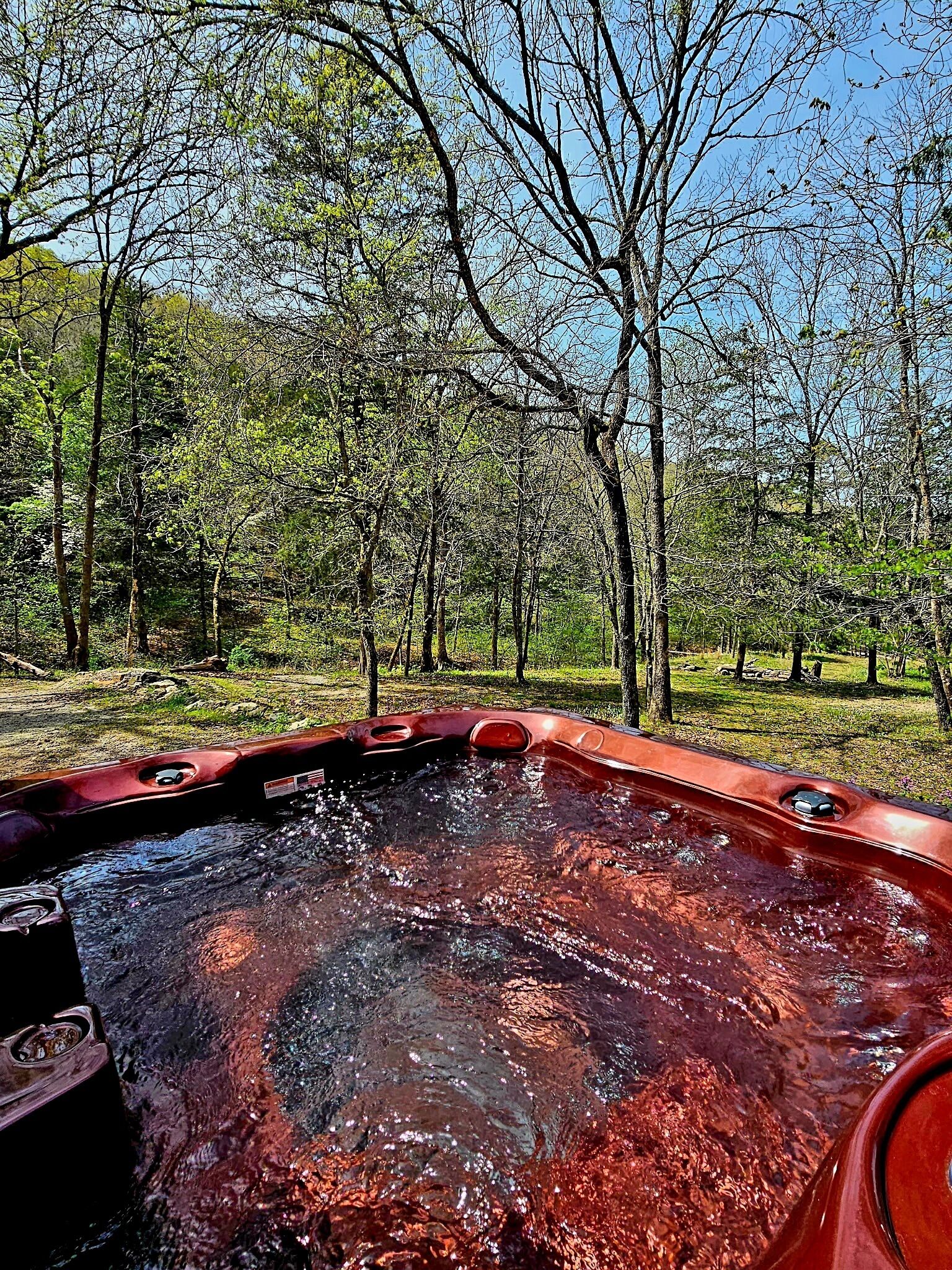 A hot tub in a natural setting with trees in the background.