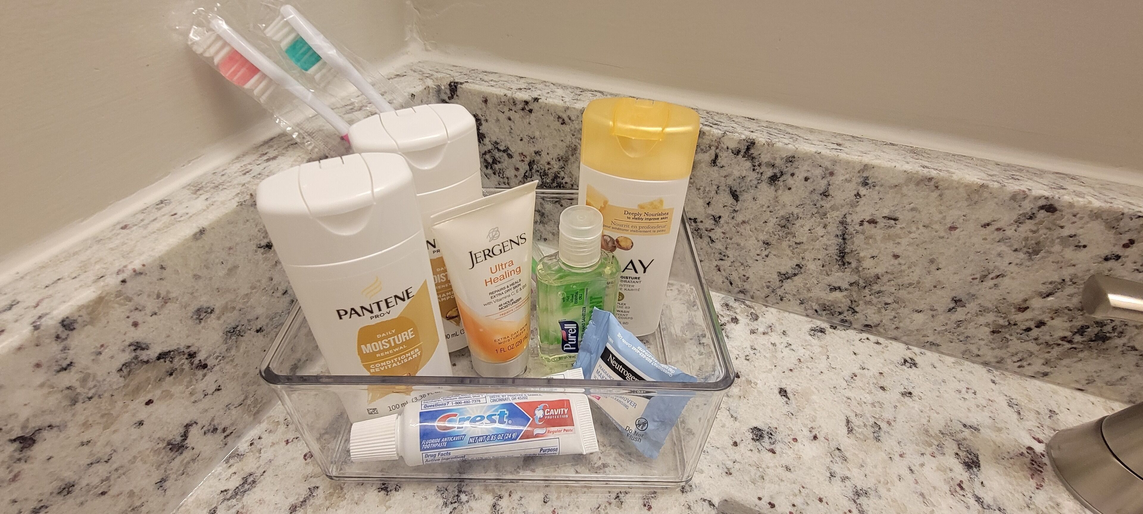 Pesualtaan yläpuolella olevalla tasolla on hygieniatuotteita, kuten Pantene-, Jergens- ja Crest-merkkisiä tuotteita.