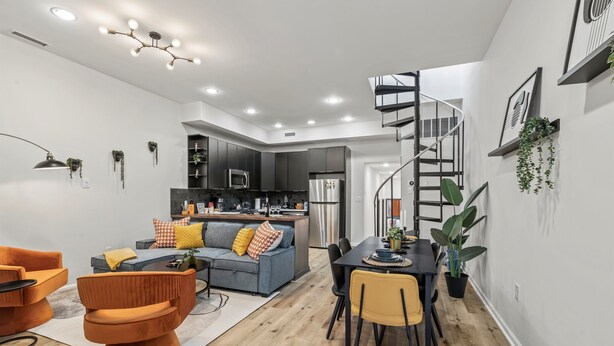 A modern kitchen with dark cabinets, a stainless steel refrigerator, and a built-in oven.