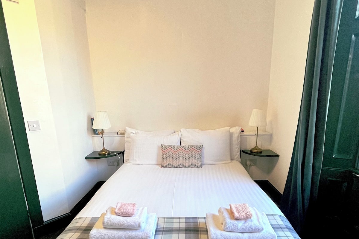 Escritorio, cortinas blackout y tabla de planchar con plancha