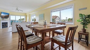 Ein Essbereich mit einem Holztisch, Stühlen und Blick ins Freie.