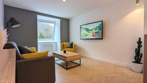 A modern living room with a sofa, armchair, and coffee table.