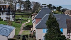 A residential area with houses, a pathway, and a view of the sea.