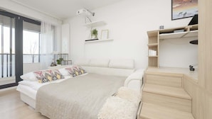 Un dormitorio moderno con una cama grande, un escritorio y una escalera.