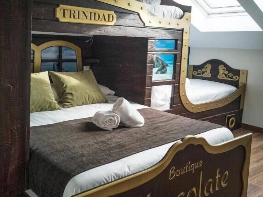 A bedroom with a bed labeled "TRINIDAD" and "Boutique Chocolate Hostel."