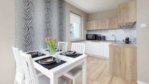 A modern kitchen with white cabinets, a microwave, and a coffee maker.