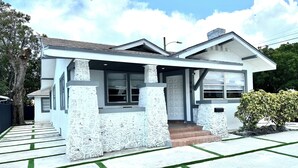 A modern two-story house with a stone facade, a front porch, and a well-maintained lawn.