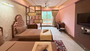 A hotel room with a bed, a desk, a television, and a balcony with curtains.