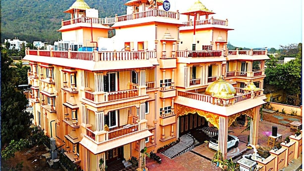 A multi-story hotel with balconies, a central dome, and a sign indicating it is a hotel.