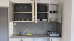 A modern kitchen with white cabinets, a sink, and a countertop. - Apartmany a Hostel Plzen Rolnicke namesti (Plzen)