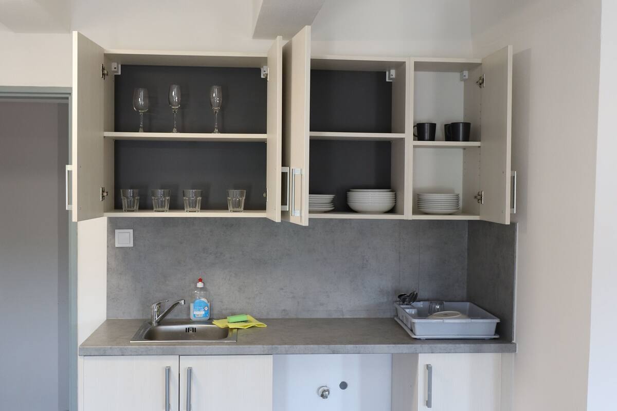 A modern kitchen with white cabinets, a sink, and a countertop.