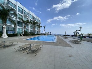 En sÀsongsöppen utomhuspool och solstolar