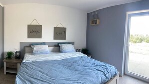 Une chambre à coucher avec un lit, deux tables de chevet et une fenêtre.