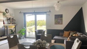 Un salon moderne comprenant un coin repas, un canapé et un téléviseur.
