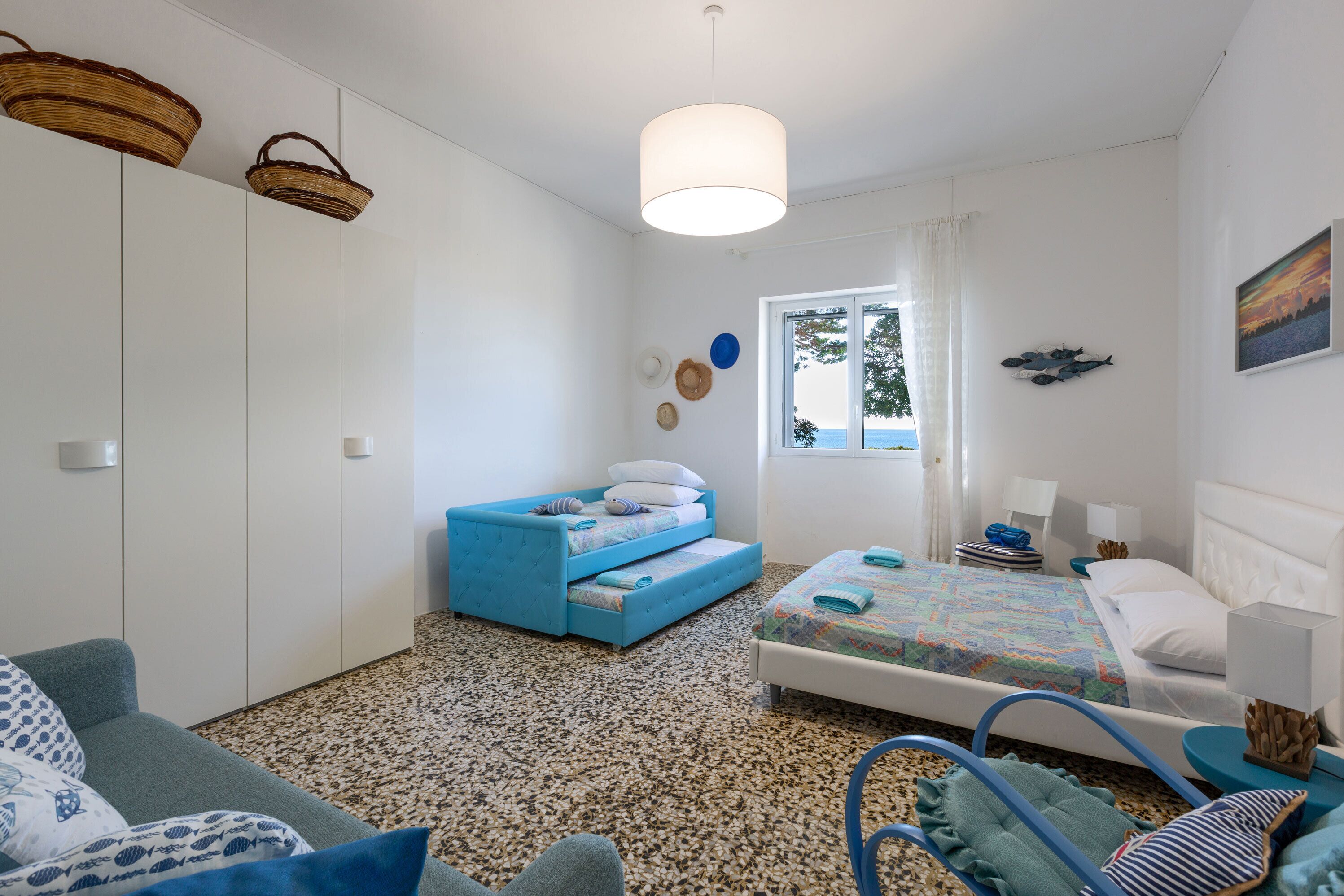 A bedroom with a bed, a sofa, and a small seating area.