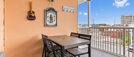 A balcony with a table and chairs, a guitar, a bell, and a sign that reads "Pirate!"